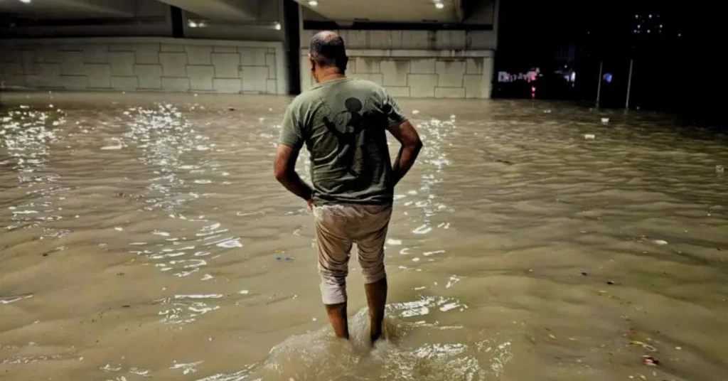 Dubai floods a man walking in flooded water in Dubai streets.